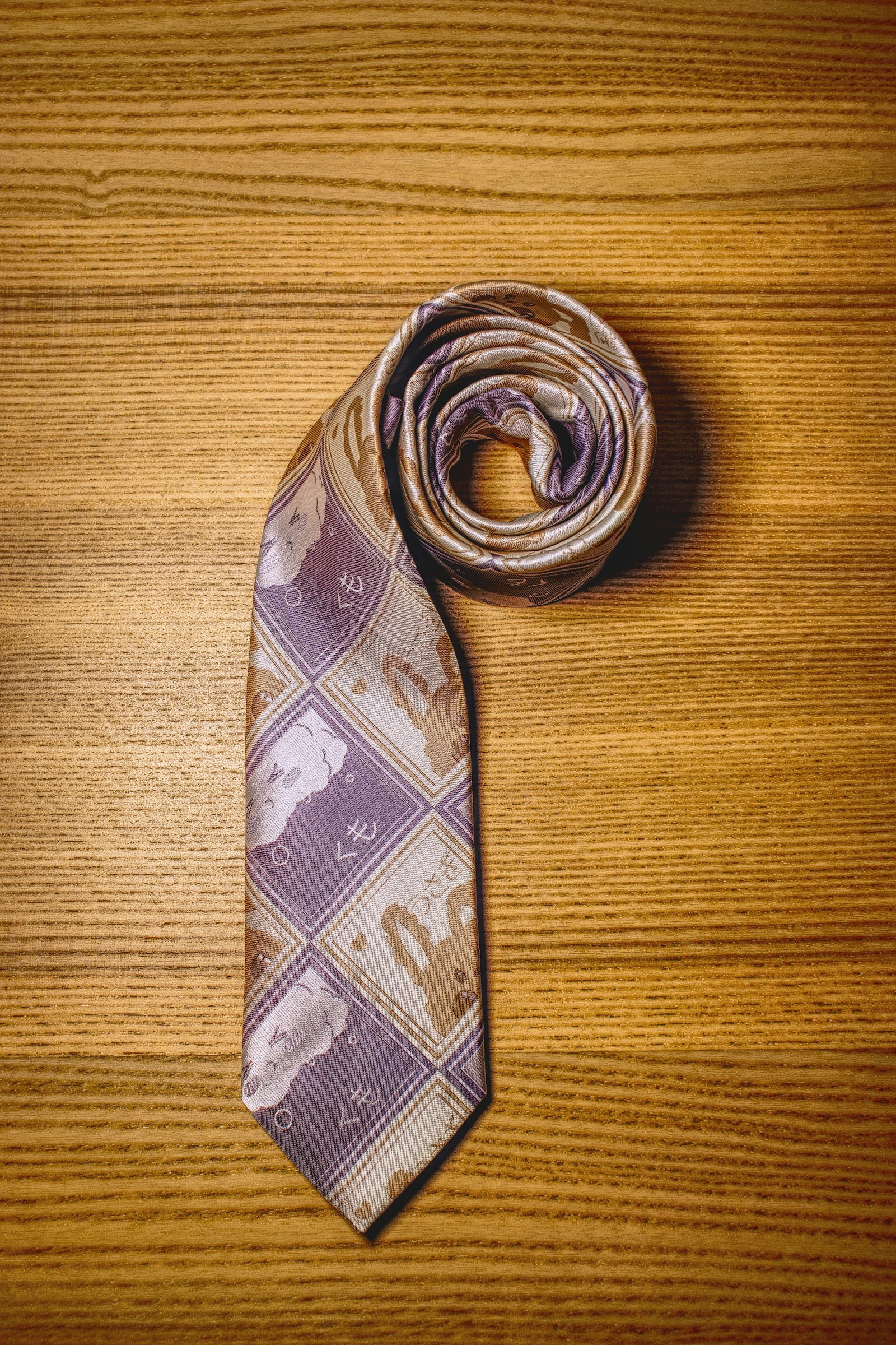 A silk necktie rolled on a wooden counter