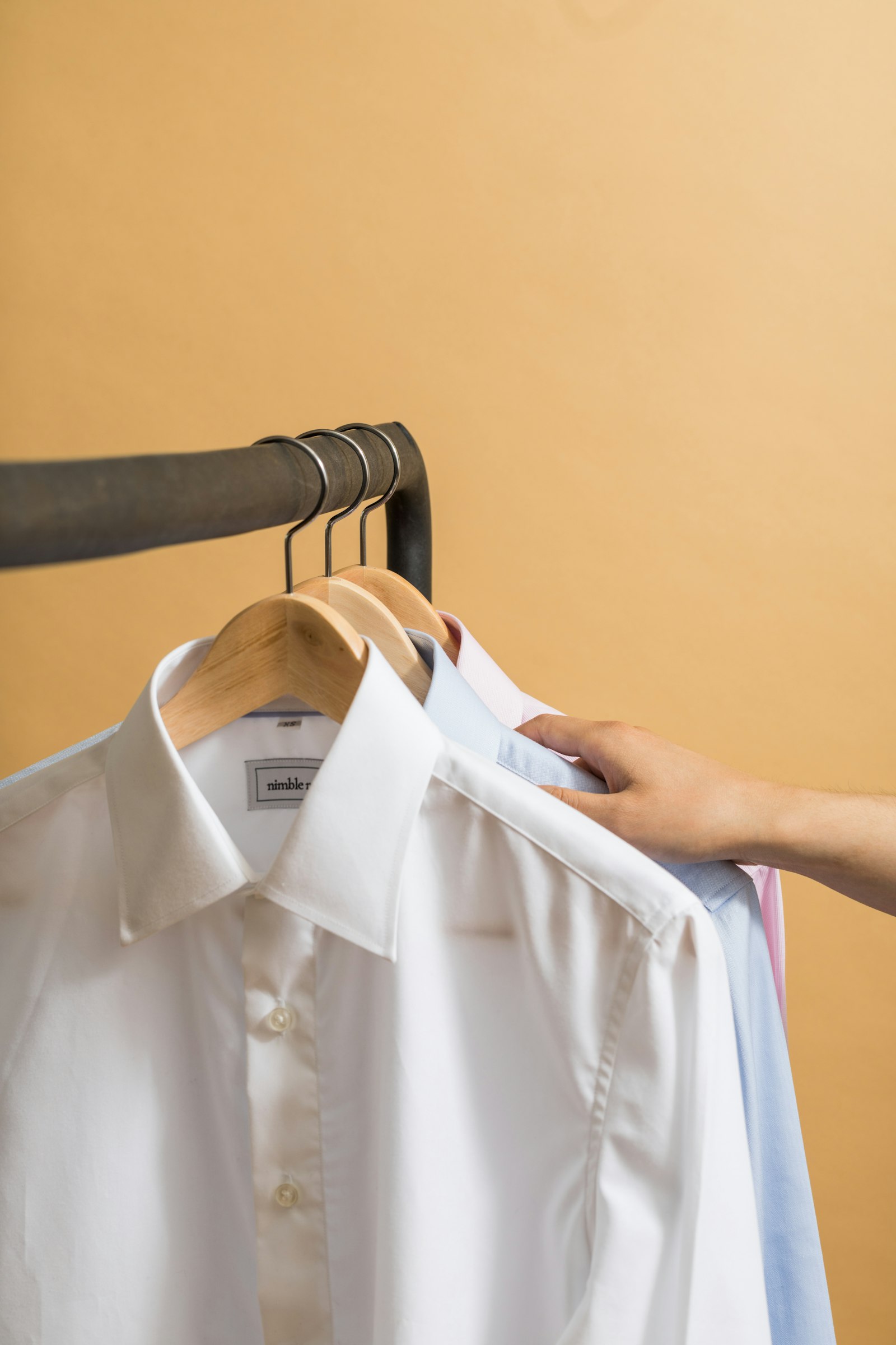 Crisp dress shirts on wooden hangers